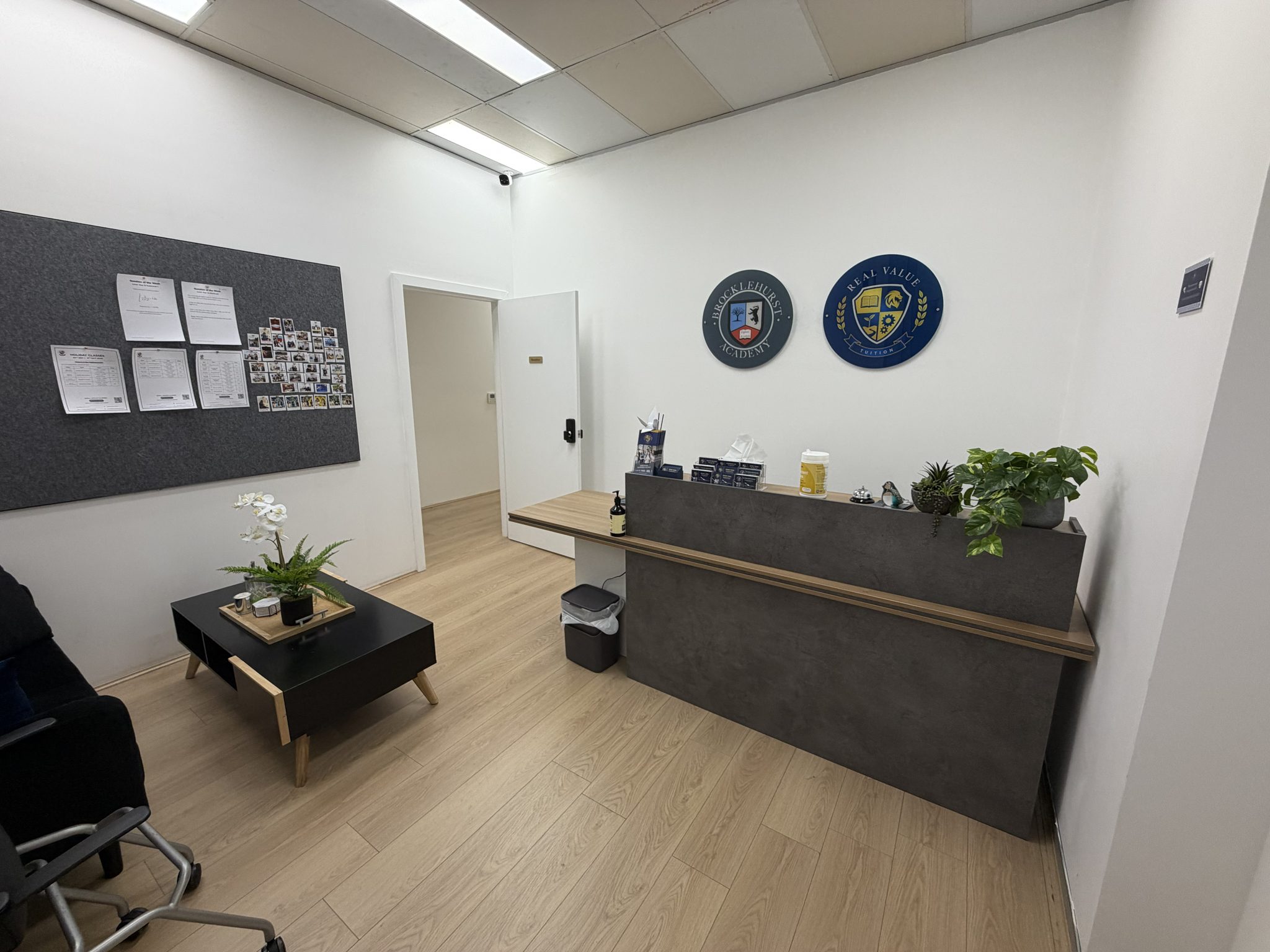 Reception desk with the Brocklehurst Academy crest on the wall