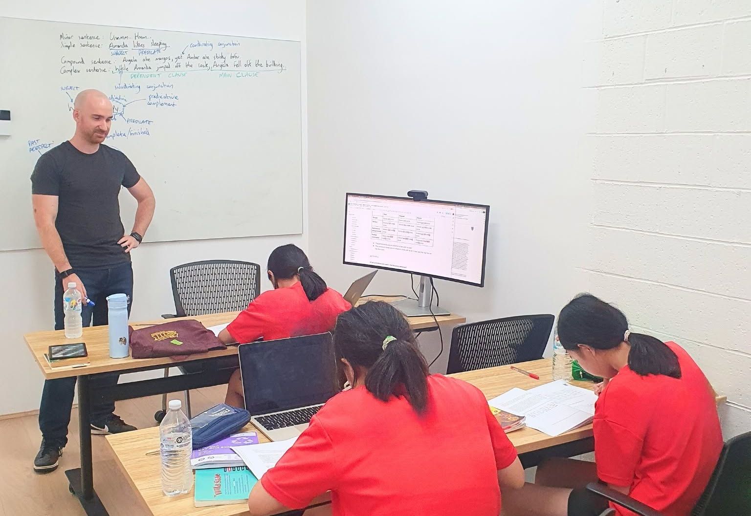 Daniel Brocklehurst teaching a small English class at the whiteboard in our Burwood centre